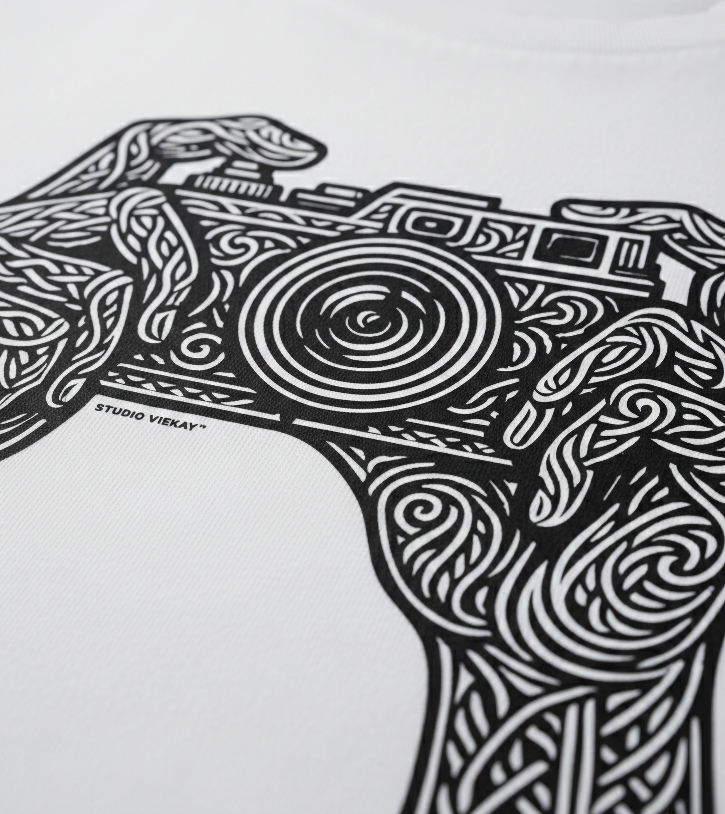 Black and white graphic design of a camera with intricate patterns on a white background, featuring the Studio Vieckay logo.