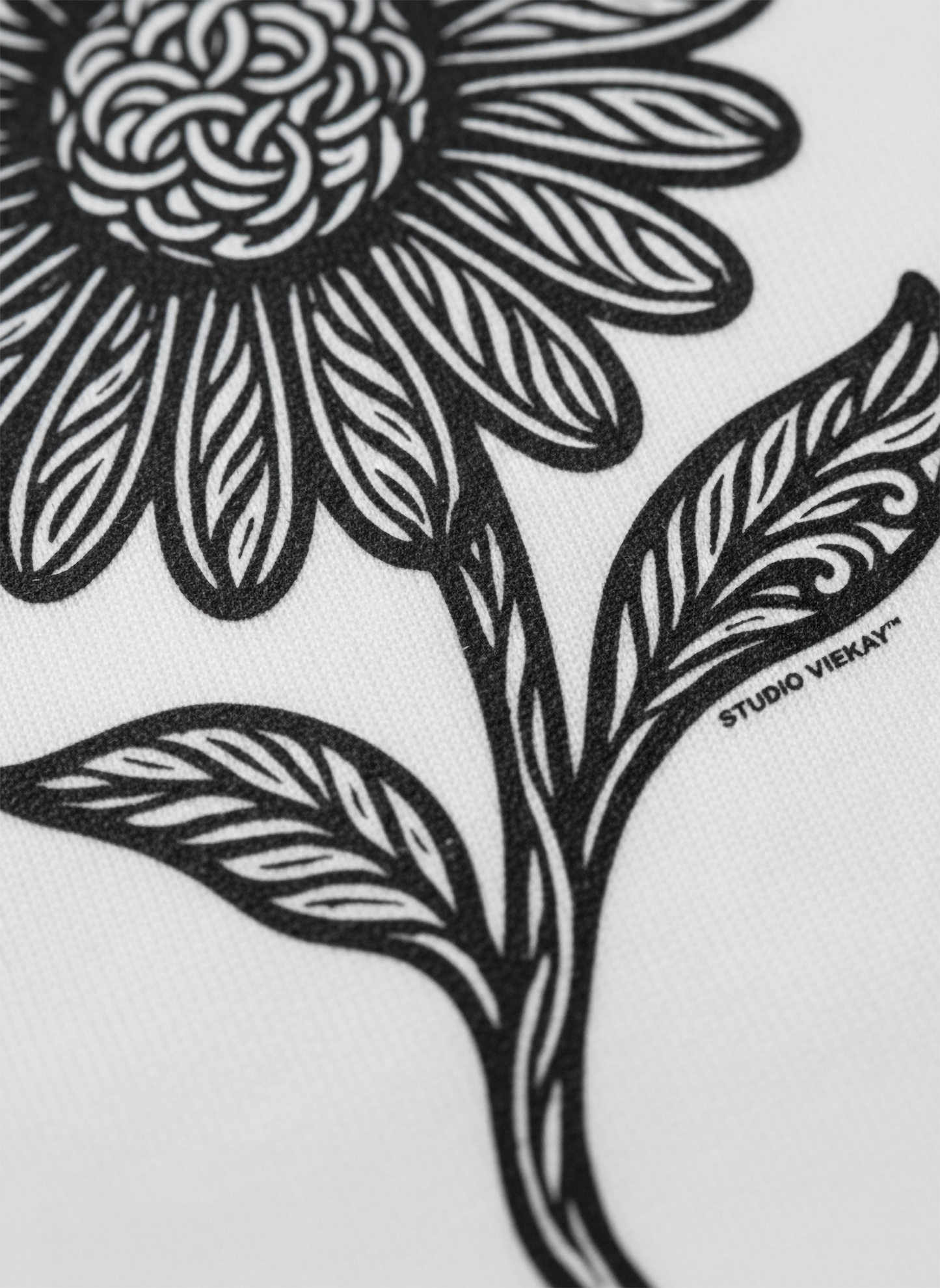 Close up of a black and white floral design with 'Studio Vieyra' branding on a white background