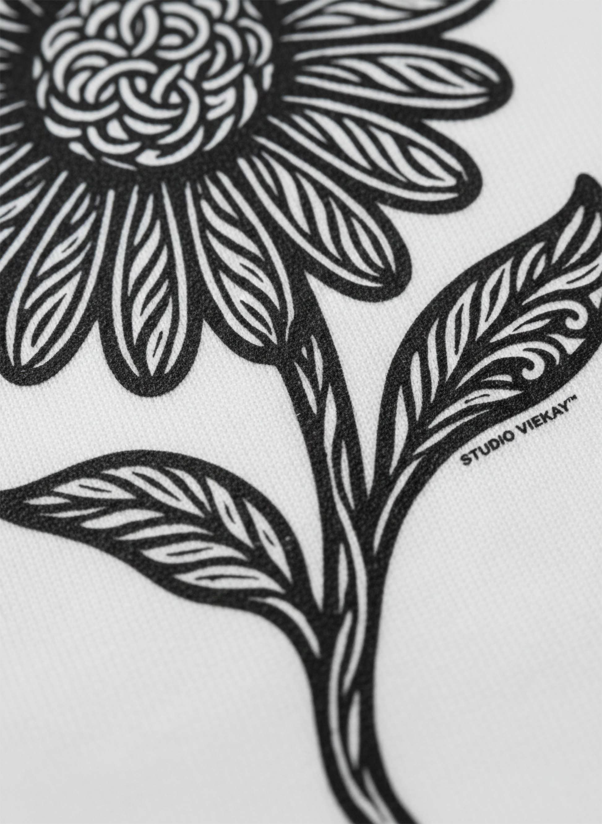 Close up of a black and white floral design with 'Studio Vieyra' branding on a white background