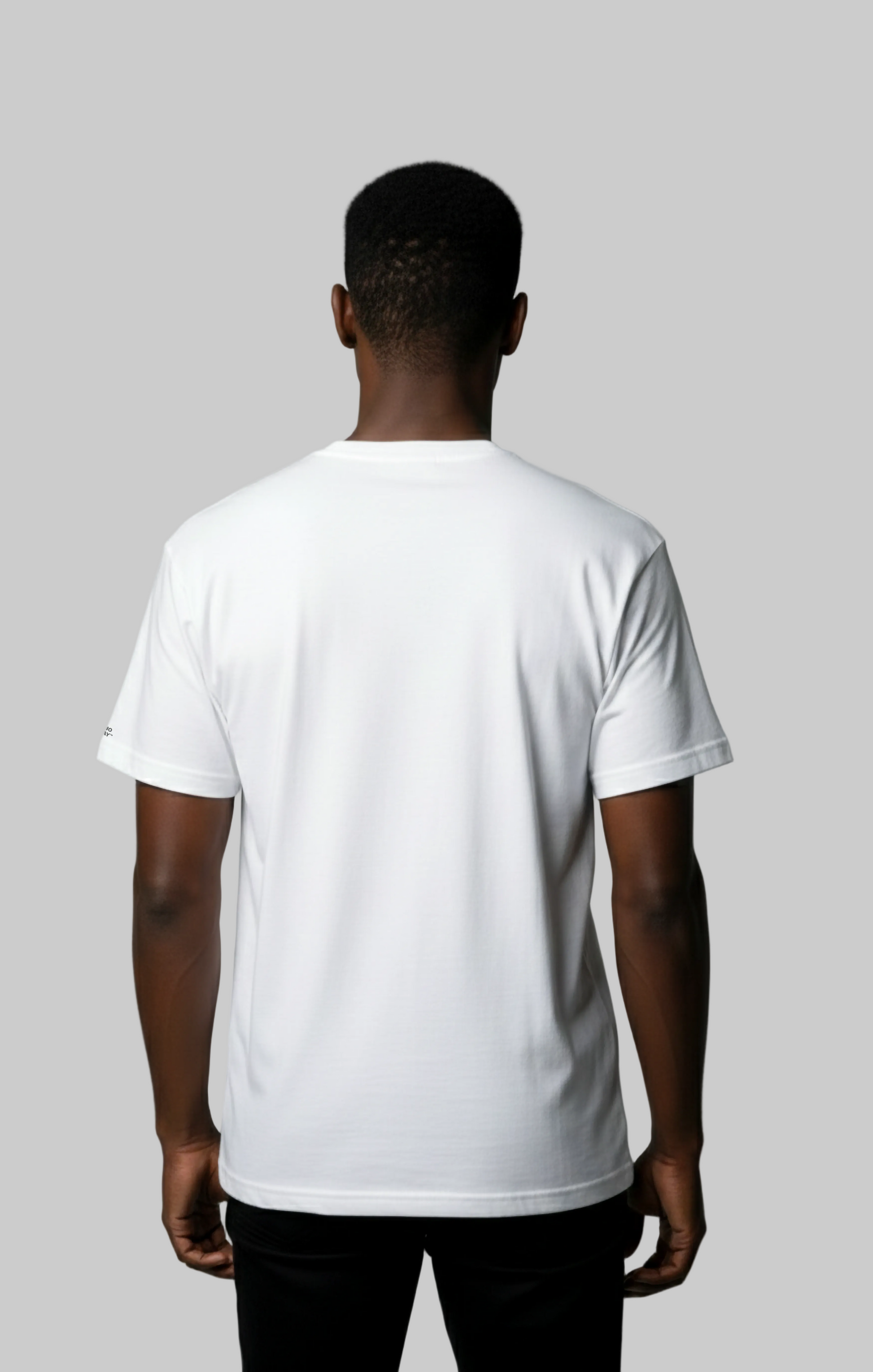 Back view of male model wearing a white t-shirt against a gray background
