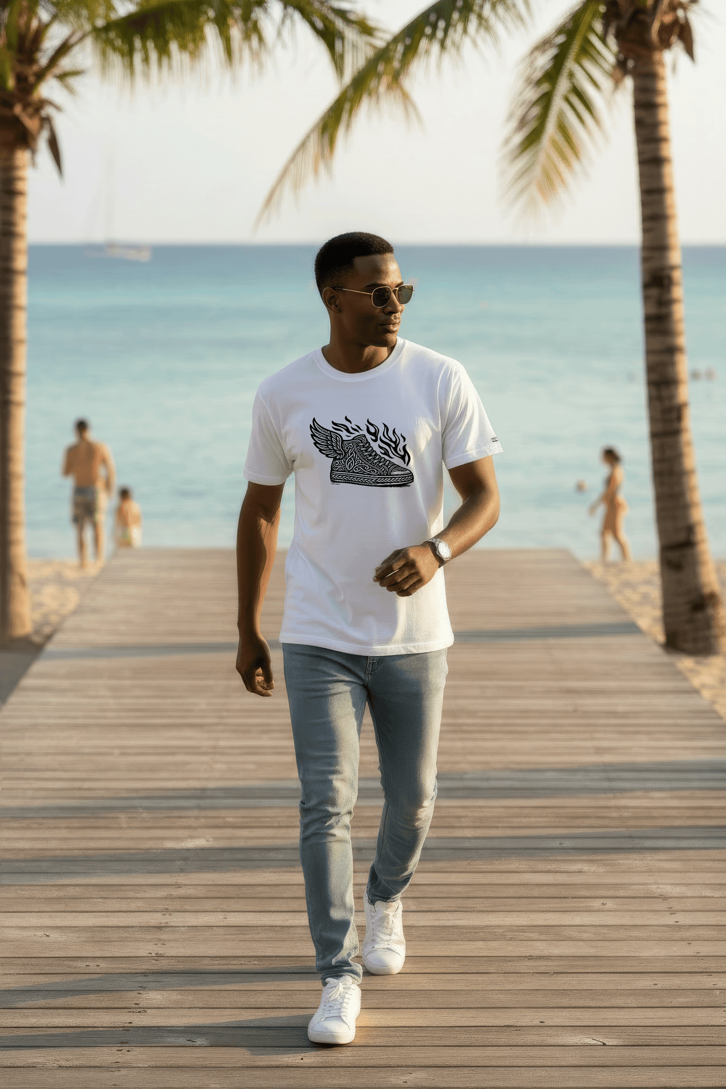 Model walking on a wooden boardwalk by the beach with palm trees in the background wearing Studio Viekay tshirt