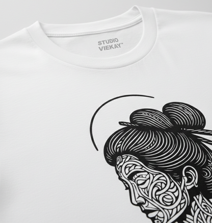 Close up of a white t-shirt with black and white graphic design of a Geisha face on a gray background