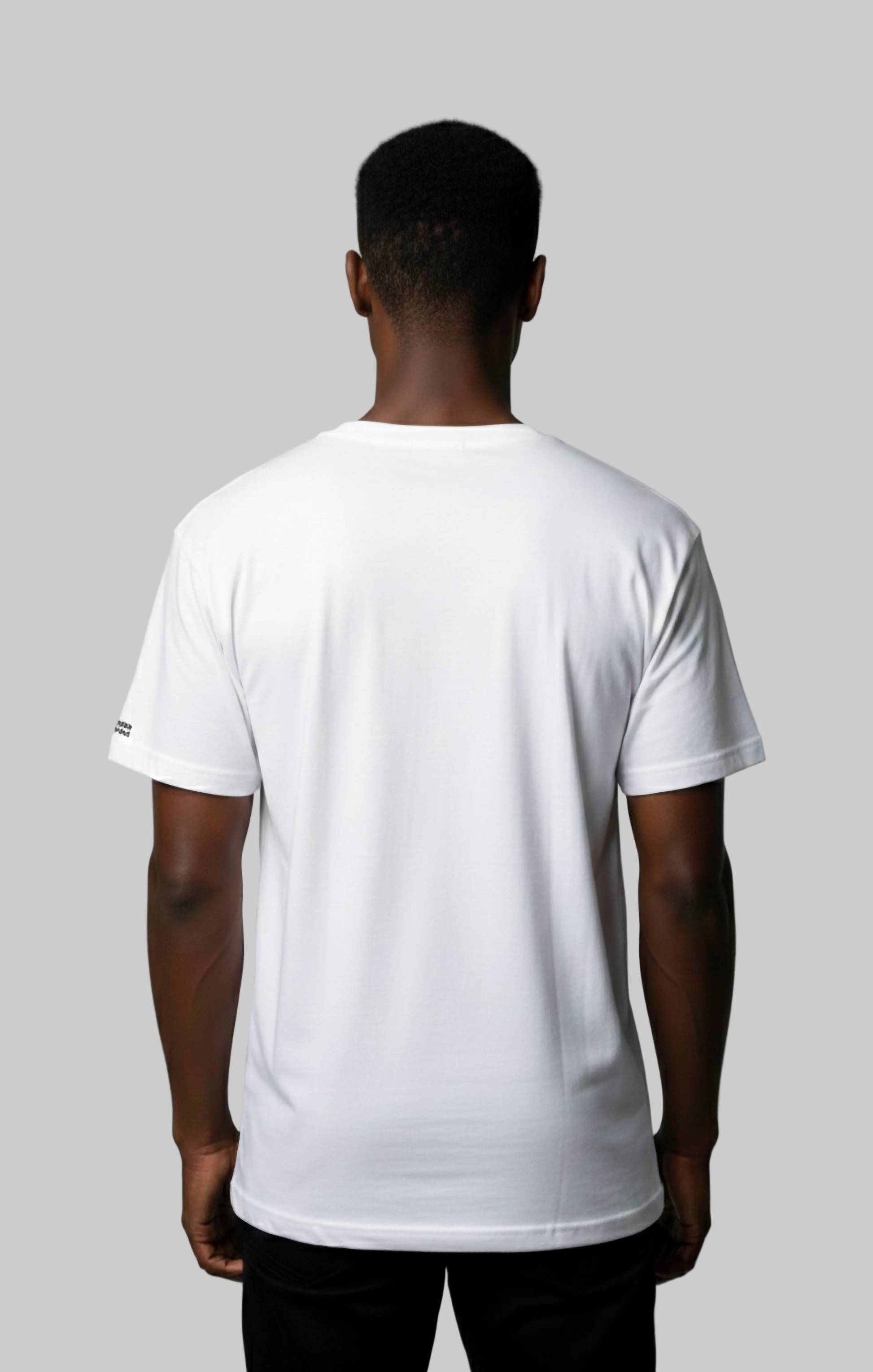 Back view of male model wearing a Studio Viekay white t-shirt against a gray background