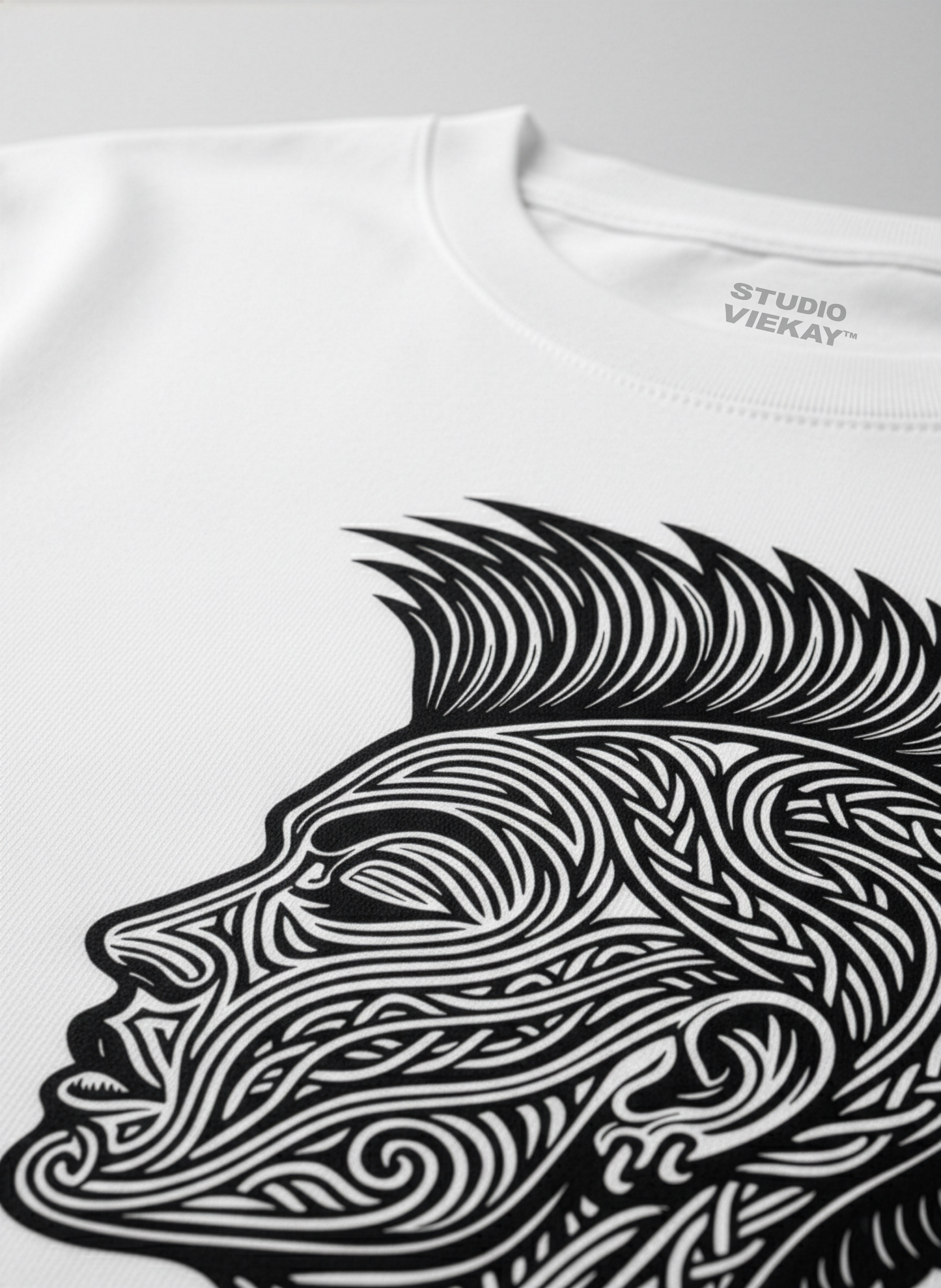Close-up of a Studio Viekay graphic of a face on a white t-shirt on a gray background