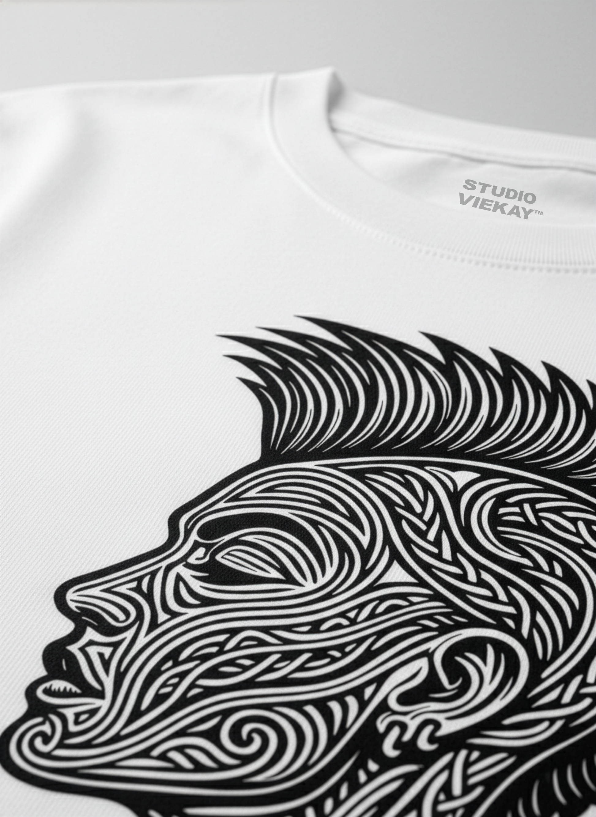 Close-up of a Studio Viekay graphic of a face on a white t-shirt on a gray background