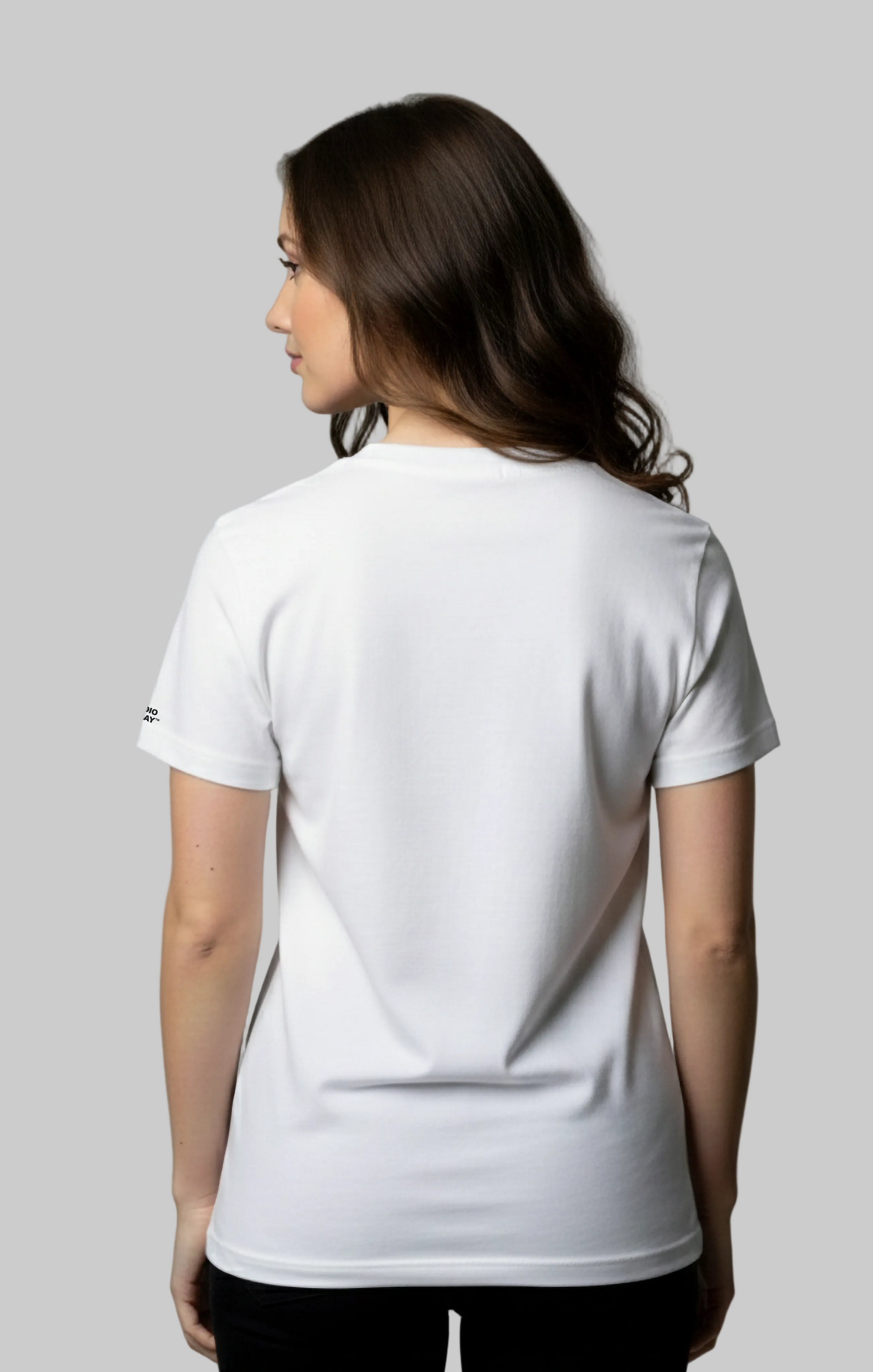 Female model wearing a plain white t-shirt against a gray background