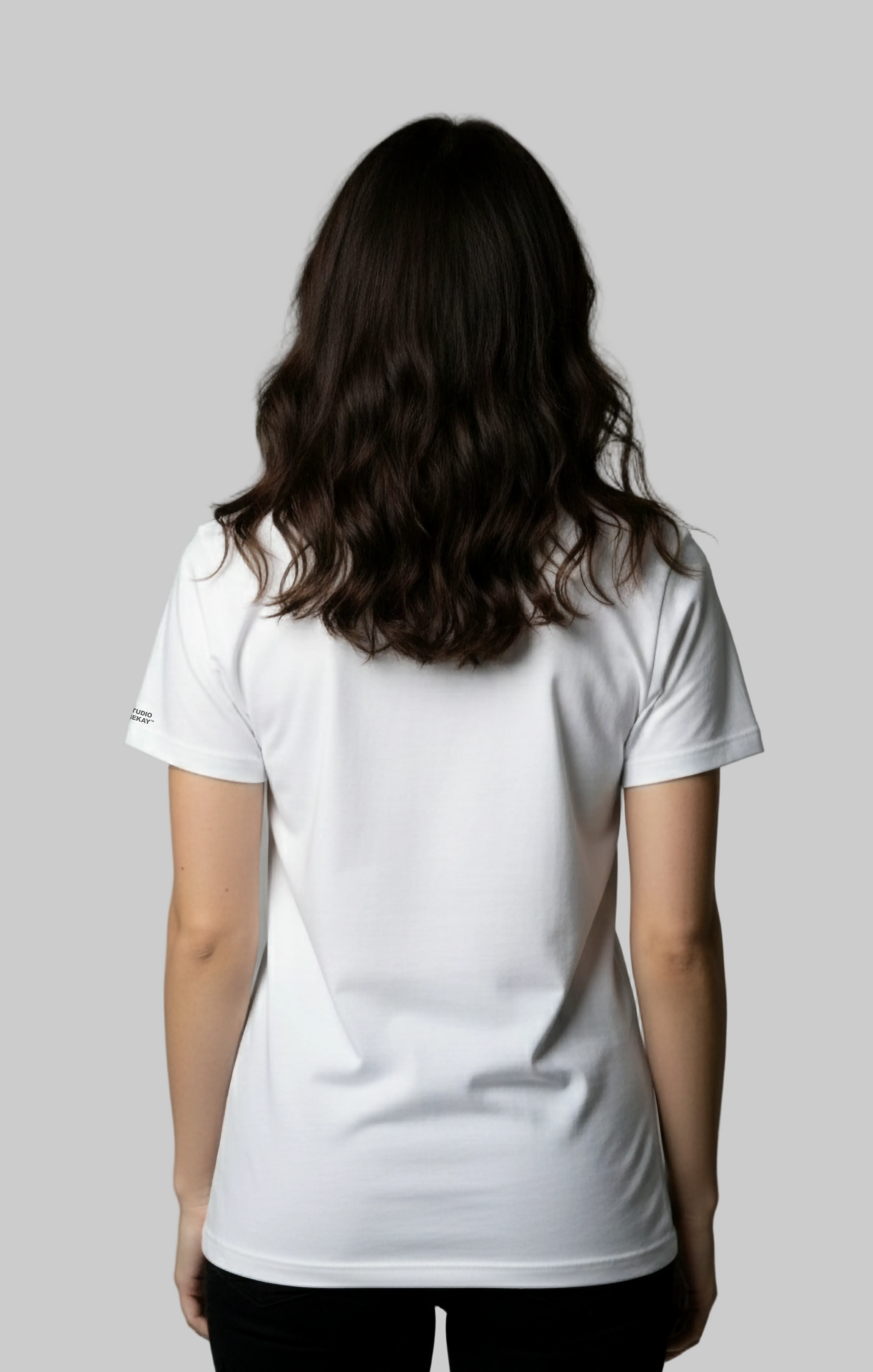 Female model wearing a plain white t-shirt against a gray background