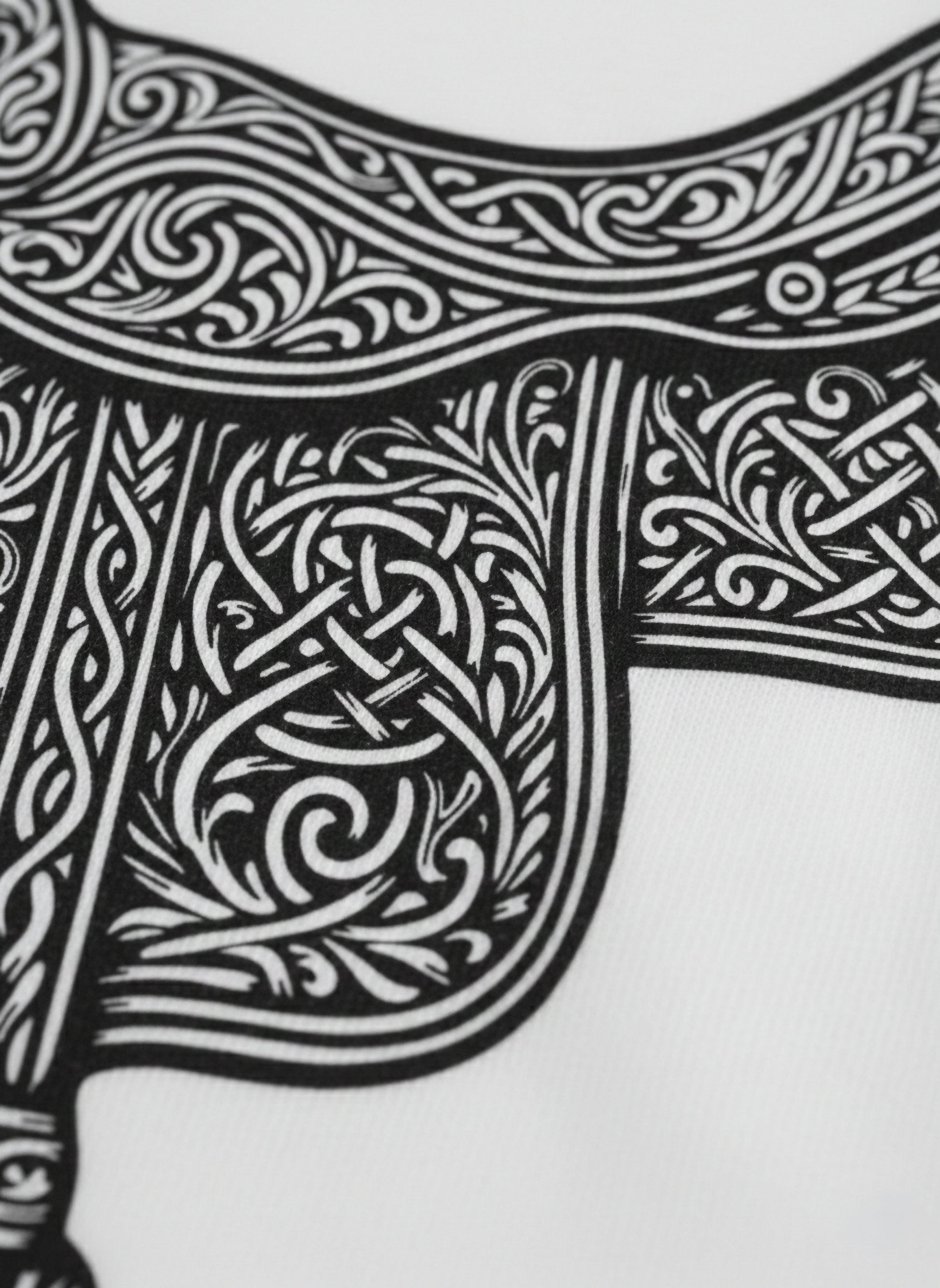 Detail of a black and white graphic of Studio Viekay pattern on a white t-shirt