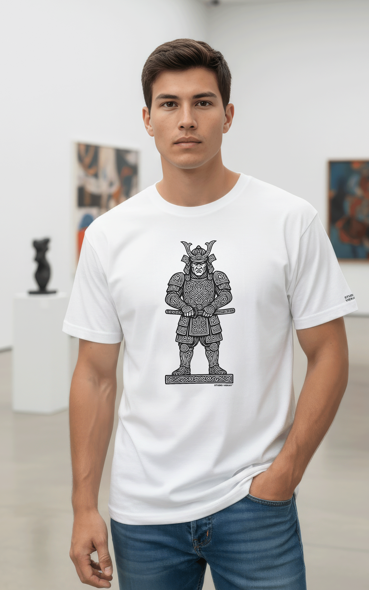 Model wearing a Studio Viekay white t-shirt with a Samurai graphic design in an art gallery.