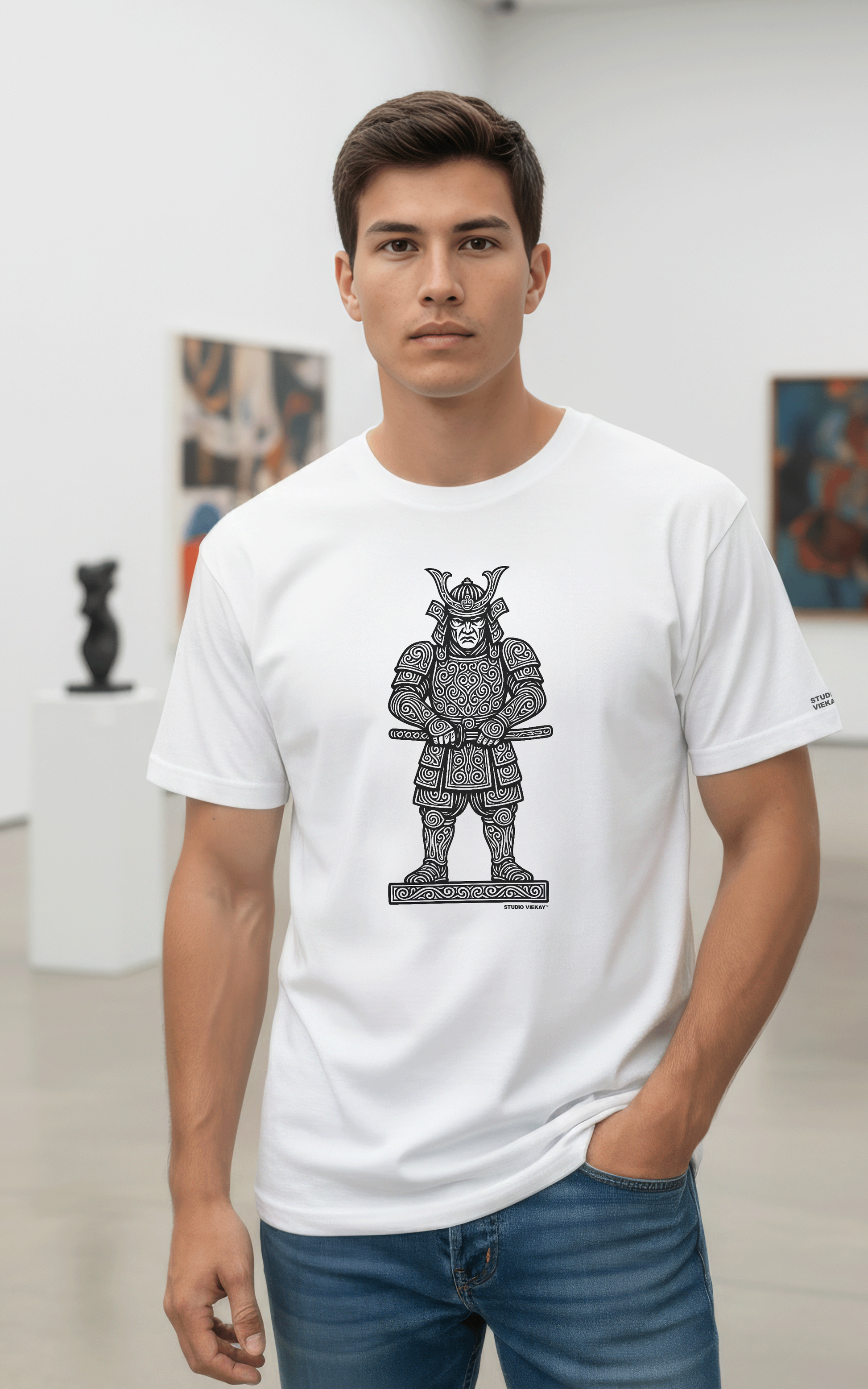Model wearing a Studio Viekay white t-shirt with a Samurai graphic design in an art gallery.