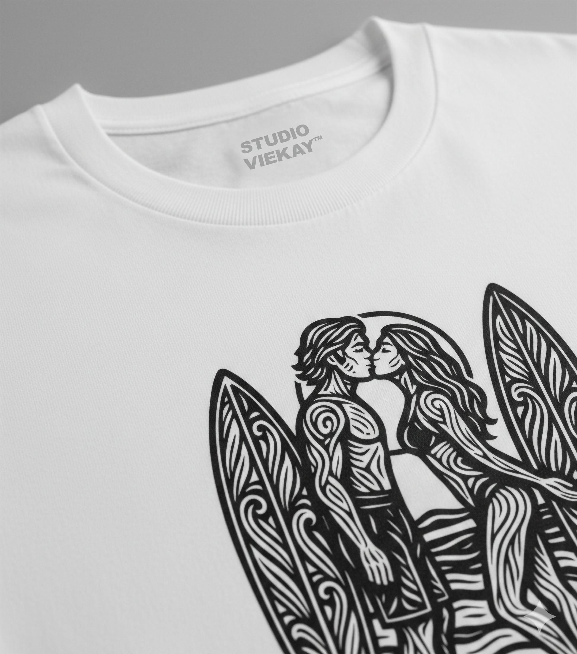 Close-up of a Studio Viekay white t-shirt with black graphic design of two people kissing next to surfboards.